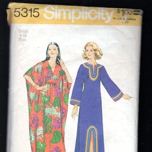 Può includere: Modello di cucito Simplicity numero 5315 per un abito lungo con scollo a V e maniche lunghe. Il modello è per le taglie 8-10 ed è etichettato "Small Miss". Il modello mostra due stili di abiti diversi, uno con una stampa floreale e l'altro in un colore viola solido.