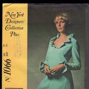 Könnte beinhalten: Ein Vintage-Schnittmuster für ein türkisfarbenes Kleid mit Rüschenkragen und langen Ärmeln. Das Schnittmuster stammt aus der New York Designers' Collection Plus und ist in Größe 14/36 Brustumfang. Das Schnittmuster trägt den Titel "N/1066" und ist von Mollie Parnis.