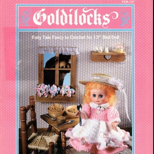 Könnte beinhalten: Ein Häkelmuster für eine Goldlöckchen-Puppe mit einem rosa-weißen Kleid, einem Strohhut und einem Löffel. Das Muster ist für eine 33 cm große Puppe und stammt von Fibre Craft Materials Corp.
