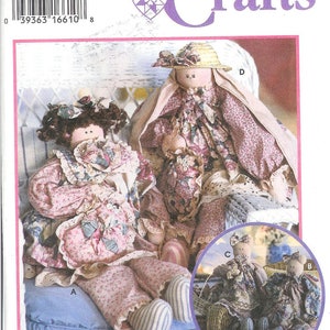 May include: Simplicity Crafts pattern number 9412 for making four dolls. The pattern includes instructions for making a doll sitting in a chair, a doll sitting on a cushion, and two smaller dolls sitting on a cushion. The dolls are dressed in floral print fabric and have brown hair.