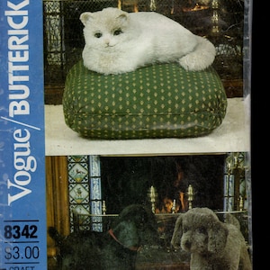 Könnte beinhalten: Ein Vintage-Schnittmusterumschlag mit einer Plüschkatze auf einem grünen Kissen und zwei Hundefiguren. Der Umschlag enthält den Text "Vogue/Butterick" und die Modellnummer 8342. Die A.S.P.C.A. profitiert von den Verkäufen dieses Musters.