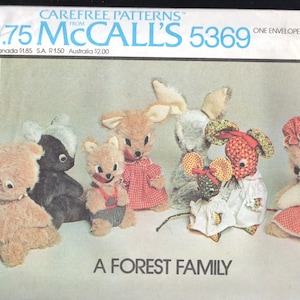 K&ouml;nnte beinhalten: Ein Vintage-McCall's-Schnittmusterumschlag mit Schnittmustern f&uuml;r Stofftiere. Die Muster umfassen einen Wolf, ein Eichh&ouml;rnchen, eine Maus, ein Stinktier, ein Kaninchen und ein Murmeltier, jedes mit Kleidung. Der Text "A Forest Family" wird angezeigt.