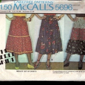 May include: McCall's 5696 sewing pattern for a tiered skirt. The pattern shows three skirt designs with floral and patterned fabrics. The package includes the text "The Tiered Skirt" and "Misses' Set of Skirts."