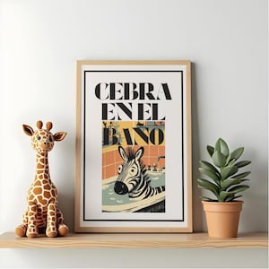May include: A framed art print with the text "CEBRA EN EL BAÑO" and an illustration of a zebra in a bathtub. A stuffed giraffe and a potted plant sit on a wooden shelf. The art print has a black border and a light wood frame.