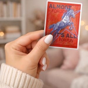 Peut inclure: Un autocollant rectangulaire avec un fond rouge et une bordure blanche. L'autocollant présente une illustration bleue d'un cheval sautant une barrière. Le texte sur l'autocollant se lit "ALMOST FORGOT" et "IT'S ALL FOR FUN".