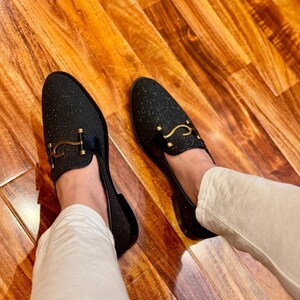Premium handmade men’s dress loafers in black glitter finish with gold bit accent and modern sophisticated style.
