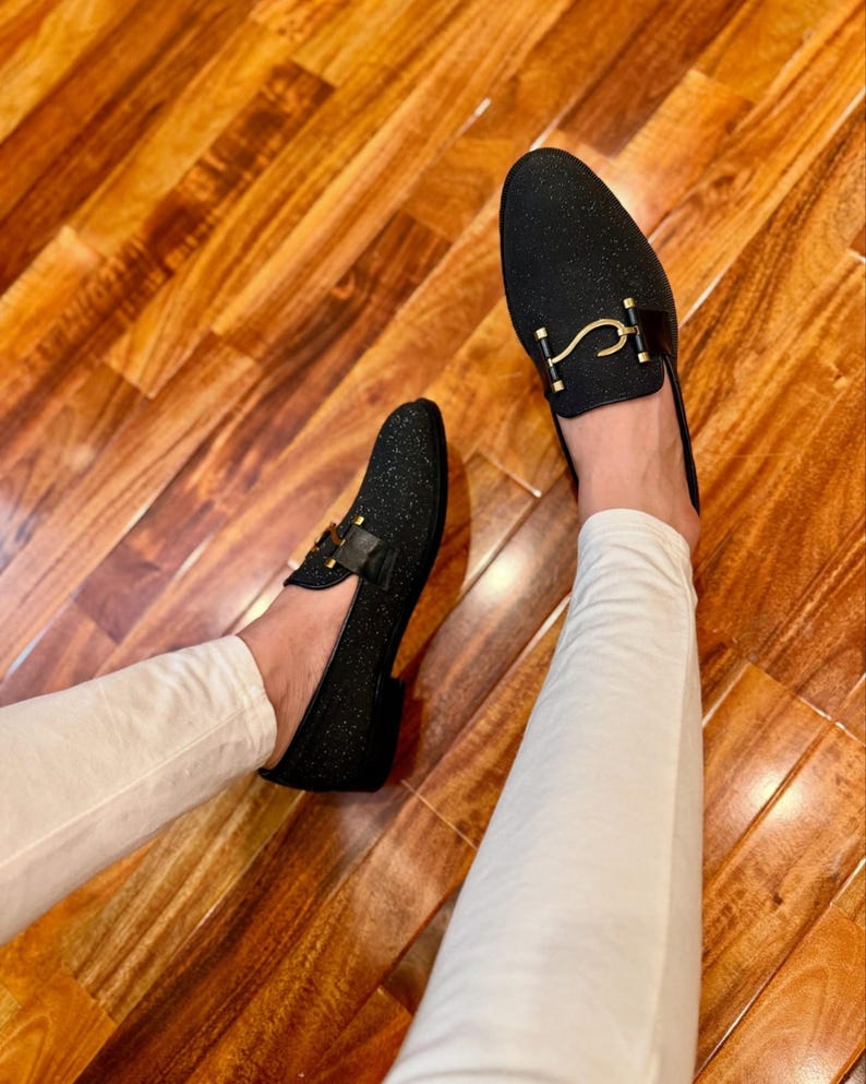 Handmade black sparkle loafers for men featuring gold metal buckle and sleek formal slip-on shoe design.