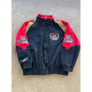 May include: Black, red, and tan NASCAR racing jacket with a full zipper. The jacket features the number 50 on the chest and sleeves, along with the NASCAR logo. The sleeves are red, and the collar is red.