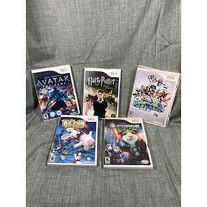以下が含まれることがあります： 5つのWiiビデオゲームケースが表示されています。「アバター・ザ・ゲーム」、「ハリー・ポッター」、「スカイランダーズ」、「レイマン・レイビング・ラビッツ」、「Gフォース」などのタイトルが含まれています。ケースにはカラフルなグラフィックとゲームタイトルが描かれています。
