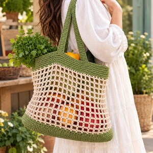 May include: A crochet tote bag featuring a solid olive green base and top border with a cream-colored open mesh center. The bag has two sturdy olive green handles and is filled with various fresh produce including green herbs, oranges, and red apples.