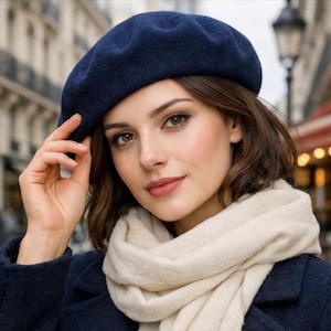 Peut inclure: Un béret bleu marine, un chapeau classique de style français, est au centre de cette image. Le béret est fait d'une matière douce. Une écharpe crème est enroulée autour du cou. Le béret est un accessoire élégant pour le temps frais.