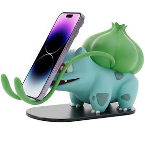 Puede incluir: Figura azul y verde de un personaje de dibujos animados sosteniendo un teléfono inteligente. La figura tiene un bulbo verde grande en la espalda y enredaderas verdes que sostienen el teléfono. El teléfono es morado y negro.