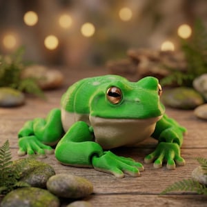 Può includere: Una dettagliata statuetta di rana verde con ventre beige chiaro e grandi occhi marroni. La rana è posizionata su una superficie di legno, circondata da piccole rocce e vegetazione. La pelle della rana ha un aspetto strutturato.