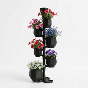 Puede incluir: Un soporte para plantas negro de varios niveles lleno de flores coloridas. El soporte presenta seis macetas de forma geométrica, cada una con flores vibrantes en tonos de rojo, rosa, azul, morado y blanco. El soporte es de metal negro.