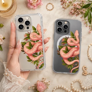 Op de afbeelding: Transparante telefoonhoesjes met een roze slang en bloemenontwerp. De slang is opgerold rond groene bladeren en kleine bloemen. De hoesjes hebben een transparante bumper.
