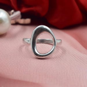 May include: A white ceramic mug with a black handle and the text "But First, Coffee" in a bold, black font. The mug is sitting on a wooden surface. The mug is approximately 4 inches tall.