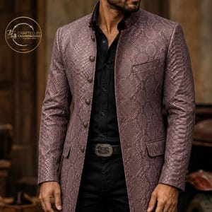 May include: A mauve-colored, long-sleeved jacket with a snakeskin pattern. The jacket has a mandarin collar, button closures, and two front pockets. The jacket is paired with a black shirt and pants. The belt has a silver buckle. The text "CRAFTED BY FASHIONZONE" is in a gold circle.