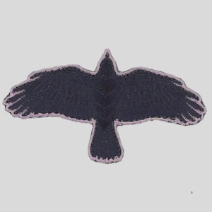 May include: A black crow patch with outstretched wings, outlined in a light purple stitch. The patch is embroidered with a detailed texture, giving it a realistic appearance. The crow is centered against a light gray background.