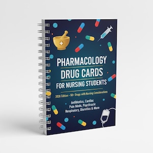 Pode incluir: Um caderno espiralado intitulado "Pharmacology Drug Cards for Nursing Students". A capa é azul escuro com ilustrações de comprimidos, uma seringa e um almofariz e pilão. O texto inclui "2026 Edition - 50+ Drugs with Nursing Considerations."