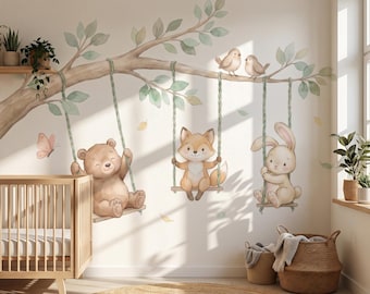May include: A wall decal featuring a large tree branch with green leaves, two small birds, and three rope swings. A brown bear, a fox, and a rabbit sit on the swings. A pink butterfly is visible near the bear, and falling leaves are scattered.