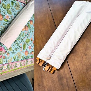 May include: A white fabric storage sleeve containing wooden components. The sleeve is long and rectangular with a drawstring closure at one end. The wooden pieces inside have a light brown finish and a notched, interlocking design structure.