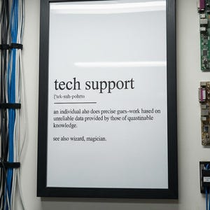 Op de afbeelding: Een ingelijste print met de woorden "tech support" in een zwarte lijst. De tekst eronder definieert technische ondersteuning als een individu dat nauwkeurig giswerk doet op basis van onbetrouwbare gegevens. De definitie eindigt met "zie ook tovenaar".