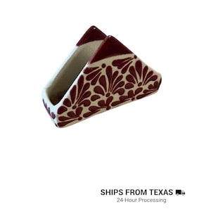 Peut inclure: Un porte-serviettes triangulaire en c&eacute;ramique avec une base de couleur cr&egrave;me et un motif floral peint &agrave; la main en rouge fonc&eacute;. Le design se compose de motifs r&eacute;p&eacute;titifs en forme de p&eacute;tales couvrant les surfaces ext&eacute;rieures, avec des bords rouge fonc&eacute;.