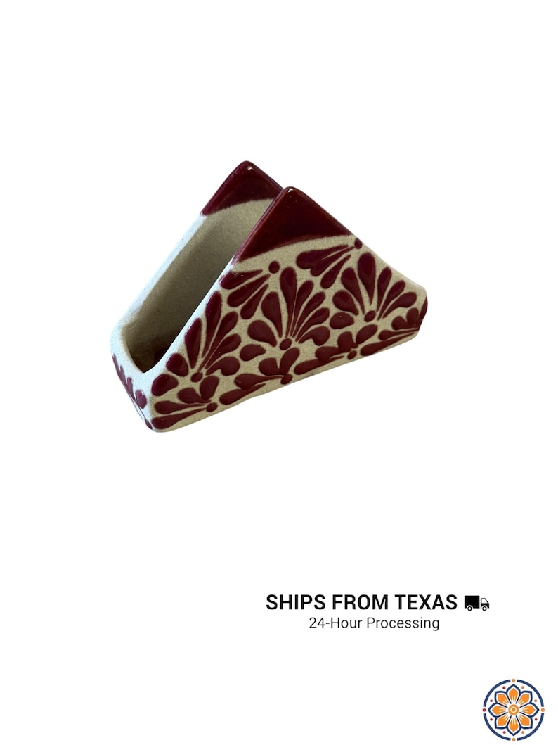 Peut inclure: Un porte-serviettes triangulaire en c&eacute;ramique avec une base de couleur cr&egrave;me et un motif floral peint &agrave; la main en rouge fonc&eacute;. Le design se compose de motifs r&eacute;p&eacute;titifs en forme de p&eacute;tales couvrant les surfaces ext&eacute;rieures, avec des bords rouge fonc&eacute;.