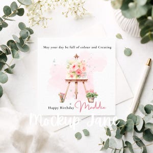 May include: A square greeting card with a watercolor painting of a canvas on an easel, adorned with pink roses. The card includes the text "May your day be full of colour and Creating" and "Happy Birthday Maddie."