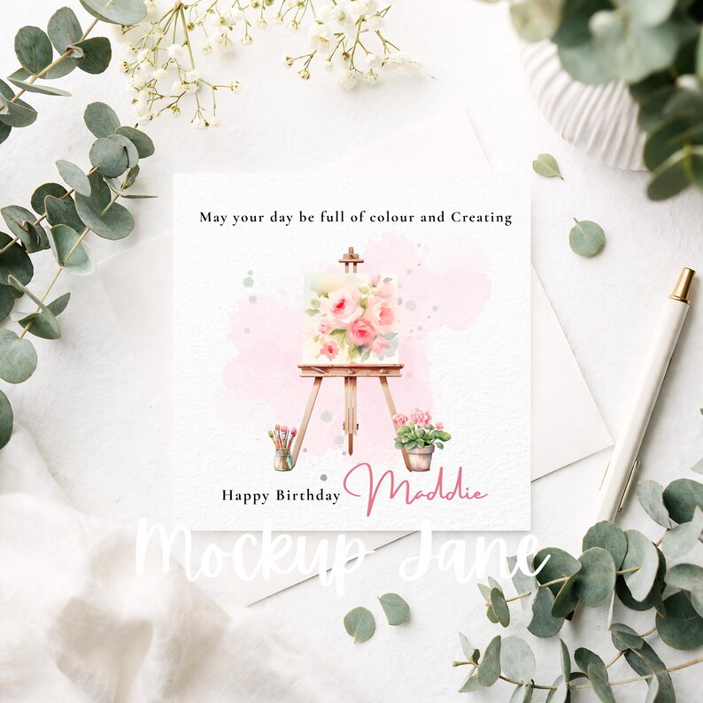 May include: A square greeting card with a watercolor painting of a canvas on an easel, adorned with pink roses. The card includes the text "May your day be full of colour and Creating" and "Happy Birthday Maddie."