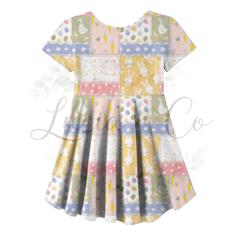 May include: A short-sleeved dress with a patchwork design featuring Easter-themed illustrations. The pattern includes bunnies, eggs, carrots, and floral elements in pastel colors like yellow, pink, and blue. The dress has a flared skirt and a scoop neckline.