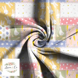 May include: A patchwork fabric featuring a repeating pattern of bunnies, carrots, and eggs in pastel colors. The design includes squares of yellow, pink, blue, and green, with a textured surface. The fabric is suitable for Easter-themed crafts.