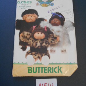 May include: A vintage sewing pattern for Cabbage Patch Kids clothes. The pattern is for a black fur coat, a white fur coat, and a leopard print coat. The pattern is from Butterick and is labeled "New".
