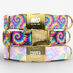 May include: Three personalized dog collars with gold-colored buckles. The top two collars feature a vibrant tie-dye pattern with the names "MILO" and "STELLA" and phone numbers. The bottom collar has a pastel tie-dye design with the name "COOPER" and a phone number.