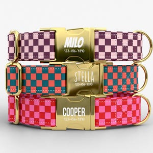 May include: Three personalized dog collars with gold-colored buckles. The collars feature a checkered pattern in pink and purple, teal and coral, and red and pink. Each buckle is engraved with a name and phone number.