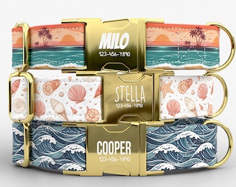 May include: Three dog collars with gold-colored buckles. The top collar has a sunset and palm tree design with the name "MILO" and a phone number. The middle collar features seashells and the name "STELLA". The bottom collar has a wave pattern and the name "COOPER".
