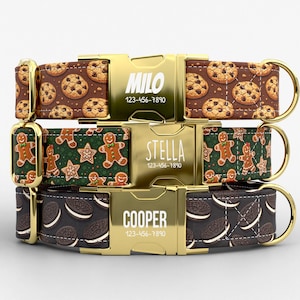 May include: Three personalized dog collars with gold-colored buckles. The top collar has a brown background with chocolate chip cookies. The middle collar has a green background with gingerbread men and stars. The bottom collar has a dark brown background with chocolate sandwich cookies.