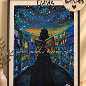 Op de afbeelding: Een ingelijst schilderij met een persoon in een donkere jurk die een boek leest in een bibliotheek met verlichte planken onder een sterrenhemel. De tekst luidt EMMA, when names become art, en THE UNIVERSE IN ONE SOUL, met een 100% HANDPAINTED zegel.