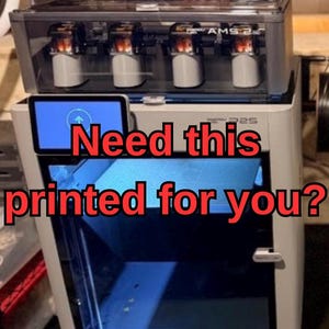 Op de afbeelding: Een witte en grijze 3D-printer met een doorzichtige bovenkant en een blauw interieur. De tekst "Need this printed for you?" wordt in het rood weergegeven. De printer heeft een klein scherm en verschillende interne componenten.