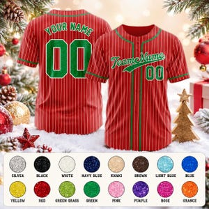 May include: A red baseball jersey with white pinstripes and green trim. The front features the text TeamName and the number 00 in green. The back displays the text YOUR NAME and the number 00 in green. A color chart with 16 glitter circles is below.