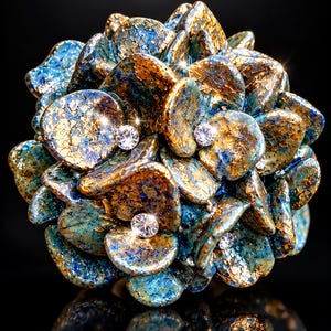 May include: A spherical decorative object composed of numerous overlapping petal-like shapes in shades of blue and metallic gold. The surface features a crackled texture, and several clear, round, faceted crystals are embedded among the petals.