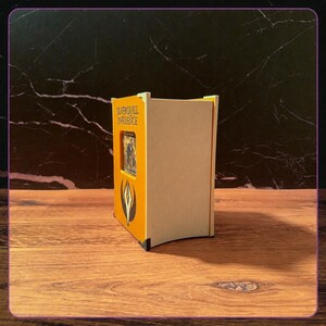 May include: A rectangular wooden deck box with a yellow front panel featuring the text Silverquill Influence and a black and white emblem. The box has a cutout window displaying a trading card, light wood side panels, and small black corner accents.