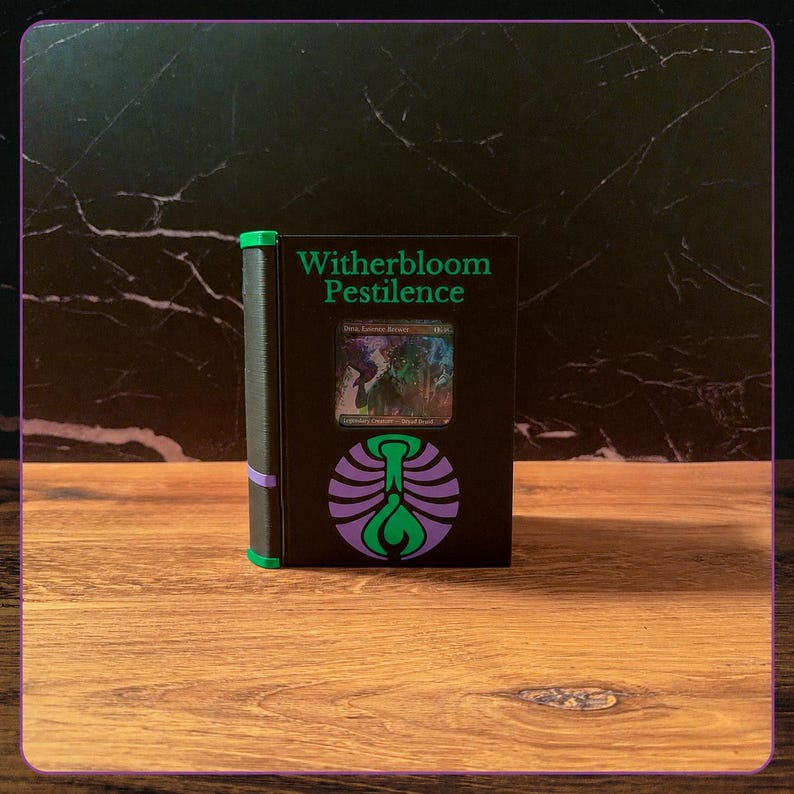 May include: A black rectangular deck box with a green spine and purple accents. The front features the text Witherbloom Pestilence in green, a circular purple and green emblem, and a central window displaying a holographic trading card.