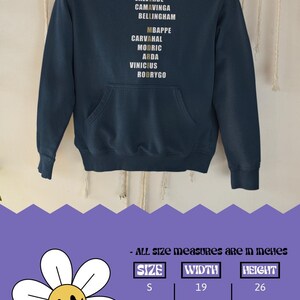 Real Madrid players lineup in their iconic white kits, standing side by side with a strong and determined presence. The backdrop captures the energy of the stadium, highlighting the unity and championship spirit of the team. Perfect for passionate Madridistas and football fans alike.