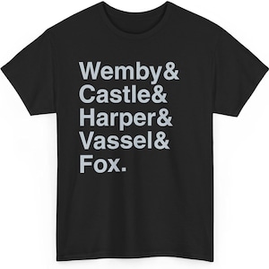 Pode incluir: T-shirt preto com os nomes "Wemby & Castle & Harper & Vassel & Fox" impressos em cinza claro. O texto está alinhado verticalmente. A t-shirt é feita de um material macio. Uma peça casual.