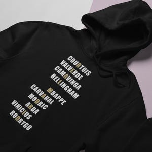 Real Madrid players lineup in their iconic white kits, standing side by side with a strong and determined presence. The backdrop captures the energy of the stadium, highlighting the unity and championship spirit of the team. Perfect for passionate Madridistas and football fans alike.