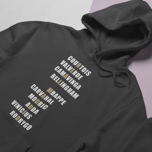 Real Madrid players lineup in their iconic white kits, standing side by side with a strong and determined presence. The backdrop captures the energy of the stadium, highlighting the unity and championship spirit of the team. Perfect for passionate Madridistas and football fans alike.