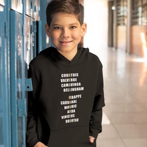 Real Madrid players lineup in their iconic white kits, standing side by side with a strong and determined presence. The backdrop captures the energy of the stadium, highlighting the unity and championship spirit of the team. Perfect for passionate Madridistas and football fans alike.