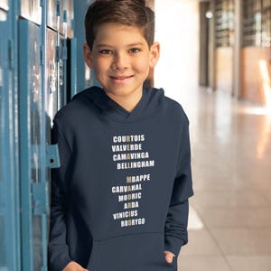 Real Madrid players lineup in their iconic white kits, standing side by side with a strong and determined presence. The backdrop captures the energy of the stadium, highlighting the unity and championship spirit of the team. Perfect for passionate Madridistas and football fans alike.