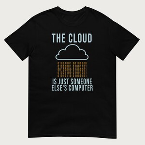 May include: A black short-sleeve t-shirt featuring a graphic with the text THE CLOUD in light blue, a light blue cloud outline, orange binary code, and the text IS JUST SOMEONE ELSE'S COMPUTER in light blue lettering centered on the chest.